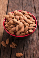 Almond nut in a ceramic bowl against wooden table
