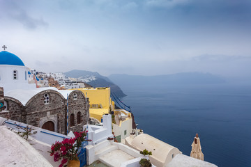 View of colorful village of Oia and caldera on a rare rainy day