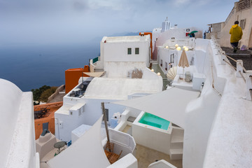 View of white houses of Oia and caldera on a rare rainy day