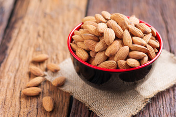 Almond nut in a ceramic bowl against wooden table