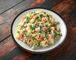 Russian traditional salad Olivier with vegetables and meat.