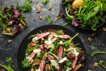 Grilled Beef Steak salad with pears, walnuts and greens vegetables and blue cheese sauce. healthy food.