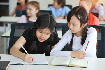 two school kids drawing in class (education concept)