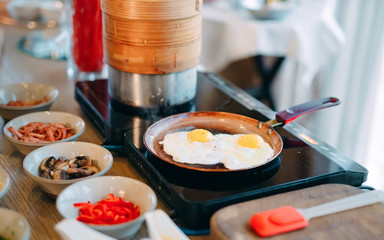 Breakfast. Scrambled eggs are cooked on an induction cooker in the restaurant.