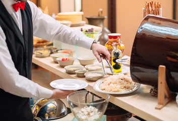 Obraz na płótnie Canvas Sauerkraut. Breakfast at the hotel or restaurant. The waiter lays the sauerkraut in the dish.