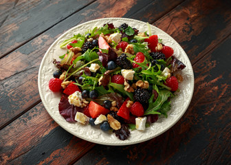 Fresh Fruit Salad with blueberry, strawberry raspberry, walnuts, feta cheese and green vegetables. healthy summer food