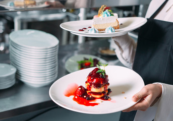 Waiter serving in motion on duty in restaurant. The waiter carries dishes.