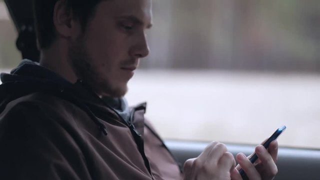 Driver use smartphone, sitting in the car. Slowmotion. Close up shoot. Tilt up.