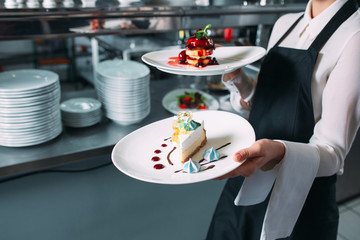 Waiter serving in motion on duty in restaurant. The waiter carries dishes.