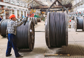 Wire rod, fittings in warehouses. worker alongside a bundle with catalkoy. industrial storehouse at...