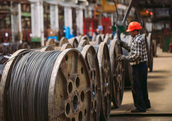 Wire rod, fittings in warehouses. worker alongside a bundle with catalkoy. industrial storehouse at...