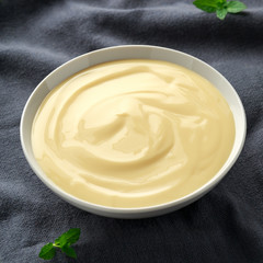 Bowl of vanilla custard on rustic background