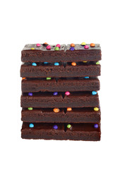 isolated stack chocolate fudge brownies with candy pieces