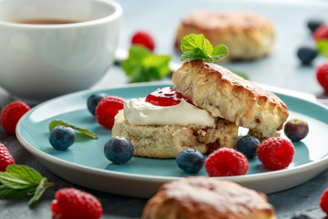 Classic scones with clotted cream, strawberries jam, english Tea and other fruit