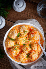 Meatballs with rice in tomato-sour cream sauce on a wooden table, top view, selective focus