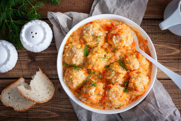 Meatballs with rice, hedgehogs, in tomato-sour cream sauce on a wooden table, top view, horizontal