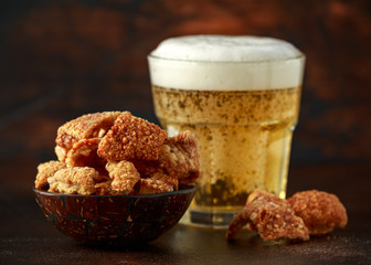 Crispy Pork scratchings with cold beer in bowl