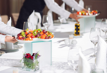 Waiters serving table in the restaurant preparing to receive guests.