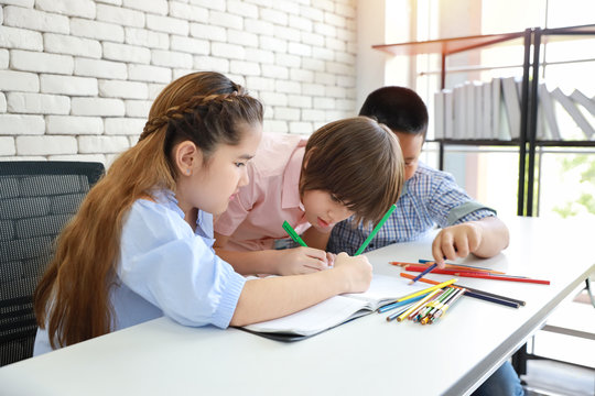 three school kids drawing in class (education concept)
