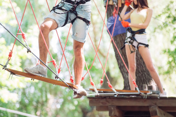couple spend their leisure time in a ropes course. man and woman engaged in rock-climbing,