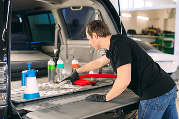 Fototapeta premium Car chemist. Chemical treatment of the car trunk.