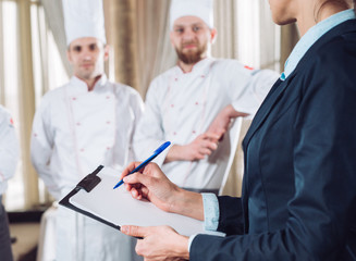 restaurant manager and his staff in kitchen. interacting to head chef in commercial kitchen.