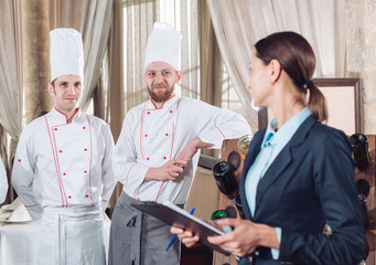 restaurant manager and his staff in kitchen. interacting to head chef in commercial kitchen.