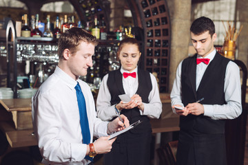 Manager's briefing with the waiters. Restaurant manager and his staff.