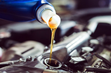 Motor oil pouring to car engine.
