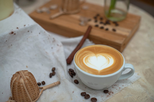 Hot Coffee cup and coffee beans roating on the wooden table 