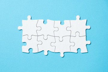 Eight pieces white jigsaw puzzle connected on blue background for business presentation