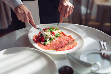 Red beef carpaccio in a white plate,
