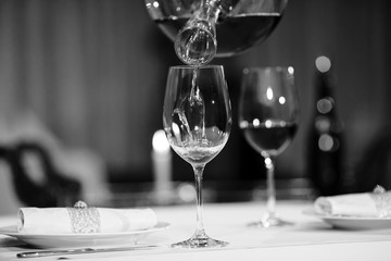 A sommelier pouring red wine into decanter
