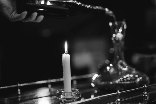 A sommelier pouring red wine into decanter