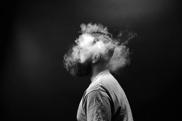 Concept. Smoke enveloped the head man. Portrait of a Bearded, stylish man with smoke. Secondhand...