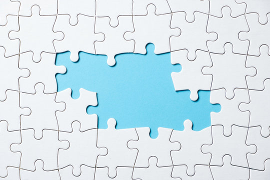 White jigsaw puzzle game pieces on blue background form a banner for business theme design