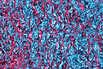 Texture of crumpled foil with neon blue pink light