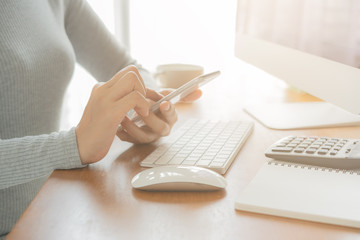 The hand of Asian women are using smartphone and computer in the office. Young women are using phones in social networks.