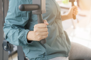 Close-up woman Weight training on machine exercise in gym. Athletic woman lifestyle is strength exercise.