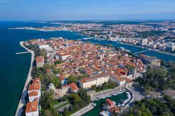 Naklejka premium Aerial view of city of Zadar. Summer time in Dalmatia region of Croatia. Coastline and turquoise water and blue sky with clouds. Photo made by drone from above.