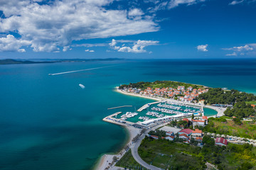 Naklejka na ściany i meble Aerial view of city of Zadar. Summer time in Dalmatia region of Croatia. Coastline and turquoise water and blue sky with clouds. Photo made by drone from above.