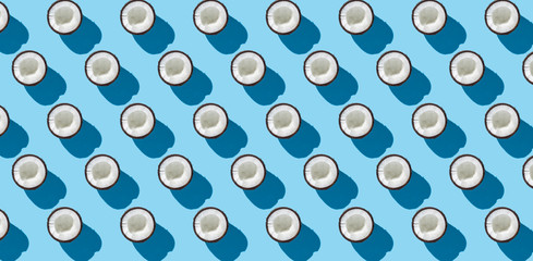 Half coconut on a blue background. Minimalism. Concept of tropics, healthy eating. Flat lay, top view.