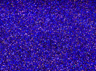 Background sequin. Violet background. Holiday abstract glitter background with blinking lights. Fabric sequins in bright colors. Fashion fabric glitter, sequins. Defocused. 