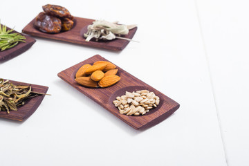dried fruits and spices on wooden tray, white table