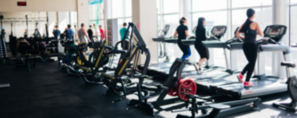 Blurred photo of a gym with people on treadmills - obrazy, fototapety, plakaty