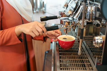 young muslim barista woman hands making coffee