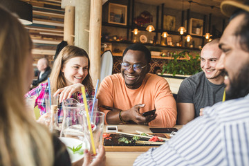 Meet young attractive people in the cafe. Friends chat, have fun, drink cocktails and eat