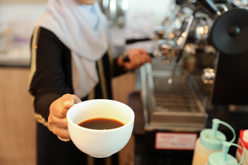 young muslim barista girl hands making coffee