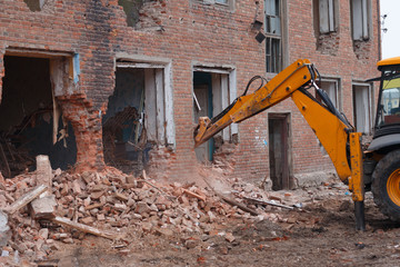 Fototapeta premium excavator bucket breaks the house