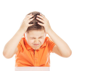 The boy is sitting at the table, holding his head with his hands. Close-up, free space for text. Isolated on a white background.